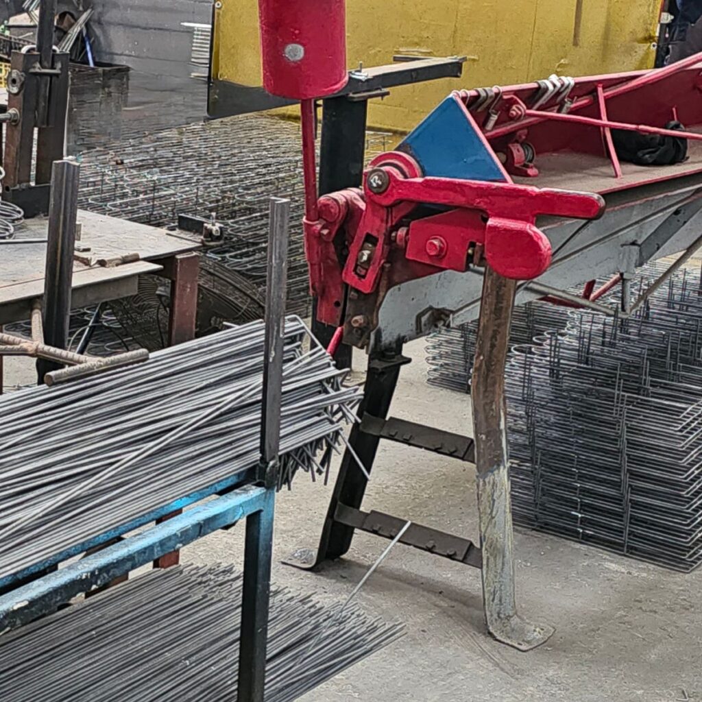 Steel bending process using hand-operated fabrication equipment in workshop